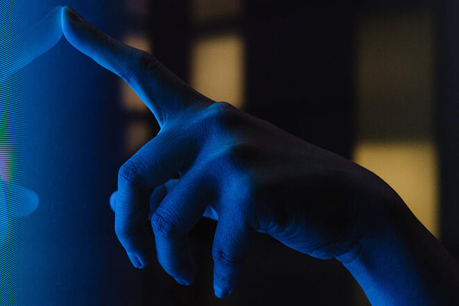 a finger pointing to a screen