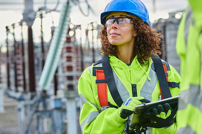 a person wearing a hard hat and safety vest, underlining the emphasis on safety protocols in the workplace.
