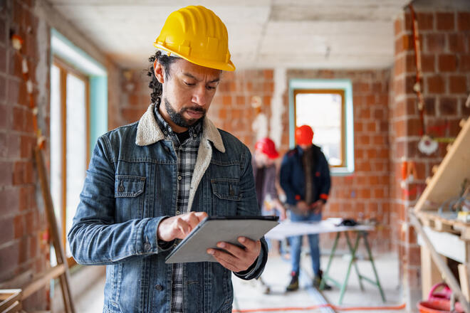 Hispanic Construction Worker Using Digital Tablet