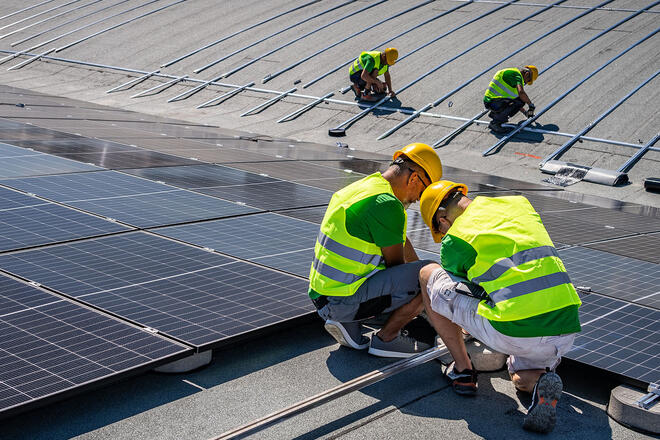 construction workers working on solar panels