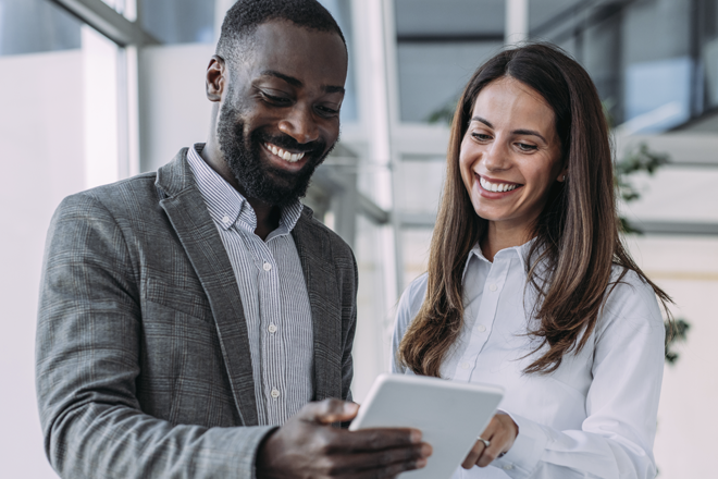 a man and a woman looking at a tablet