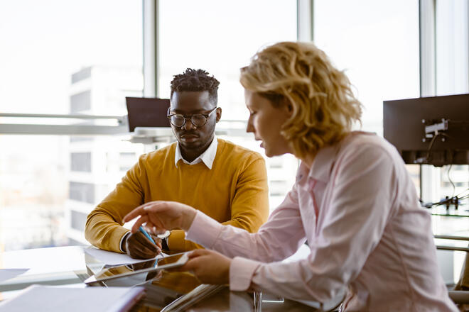 Two coworkers collaborating in an office