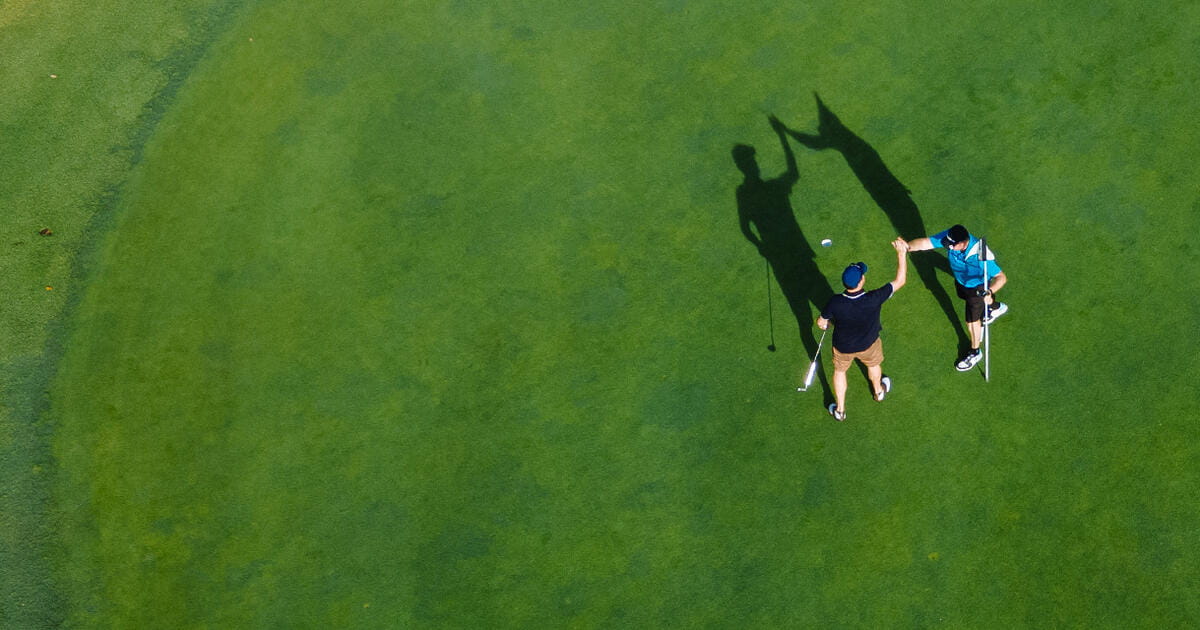 overhead shot of two golfers on the green celebrating
