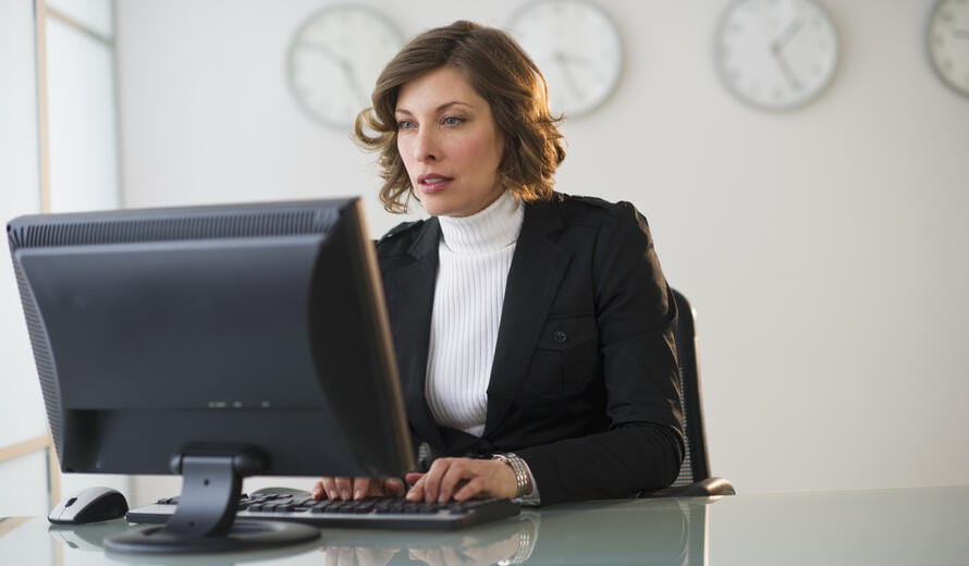 Business professional working at a computer in a modern office.