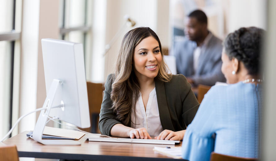 A bank manager smiles at a mature adult customer.