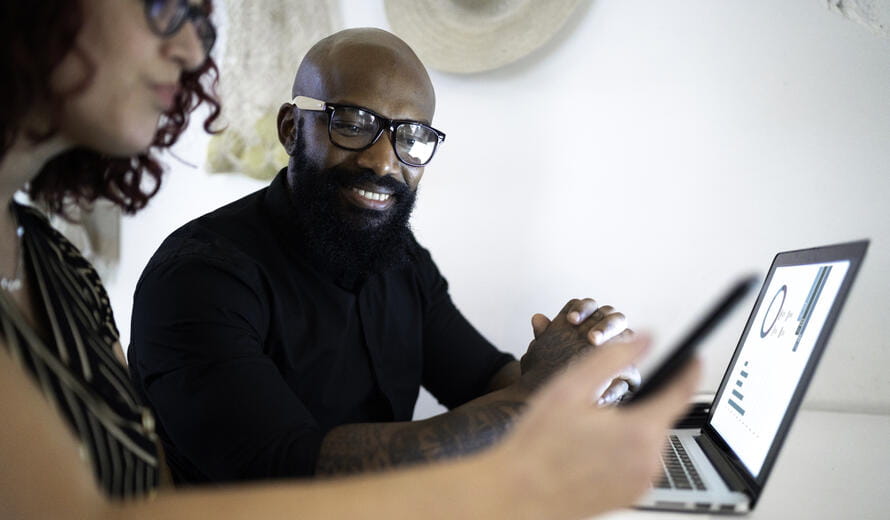 Image of a man and woman working together on a laptop and a perfect for the Resource Hub.