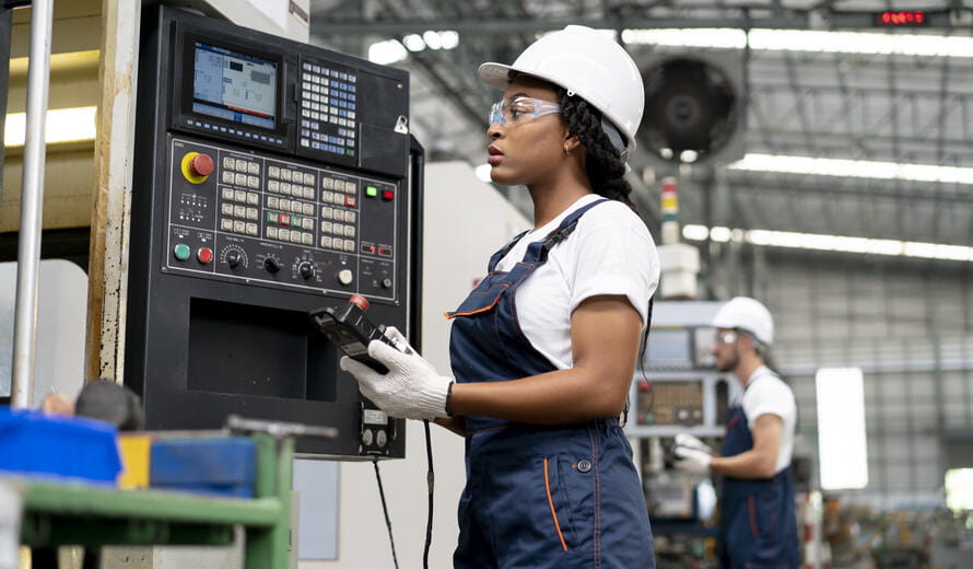 Technician woman inspecting CNC machines controlled manufacturing with computer industrial