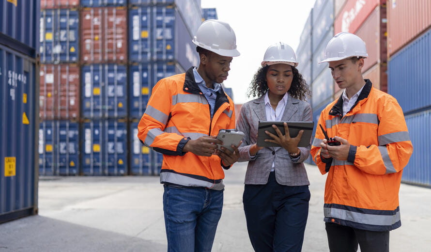 photograph showing people wearing safety gear reviewing digital devices