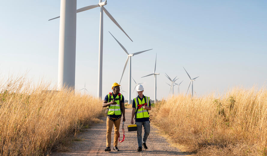 Technicians walking through a wind turbine installation site