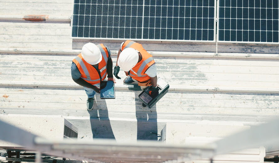 Renewable energy, solar panel and discussion, men on roof with tools at sustainable business in electricity.