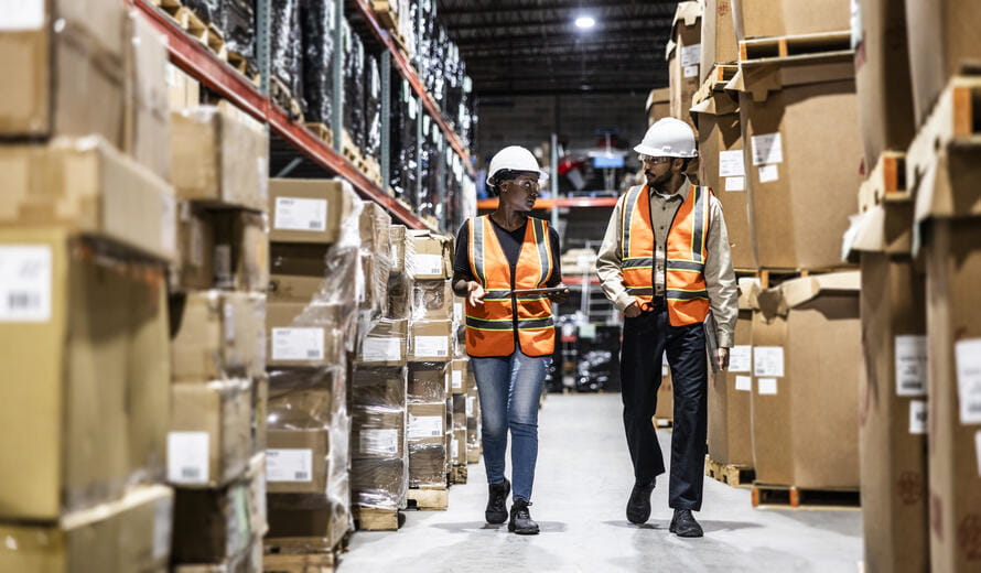 Warehouse employees walking in aisle of warehouse