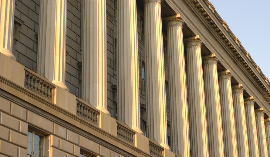 Exterior columns of a neoclassical government building in Washington, DC at sunset