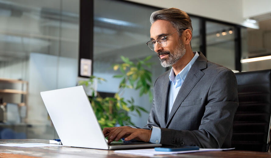 Image of a business man using a computer in a modern office