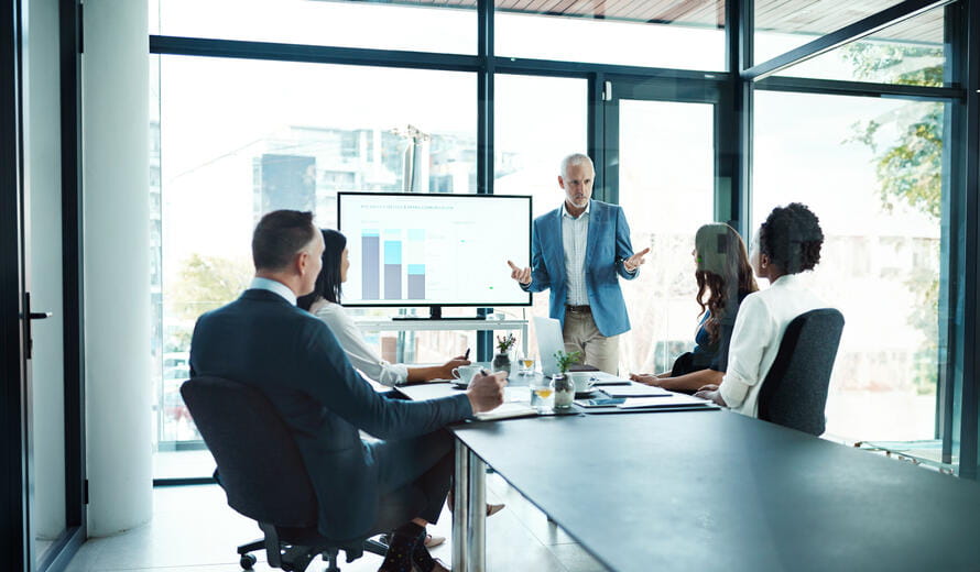 Professional office scene depicting a business leader presenting insights to a group of colleagues