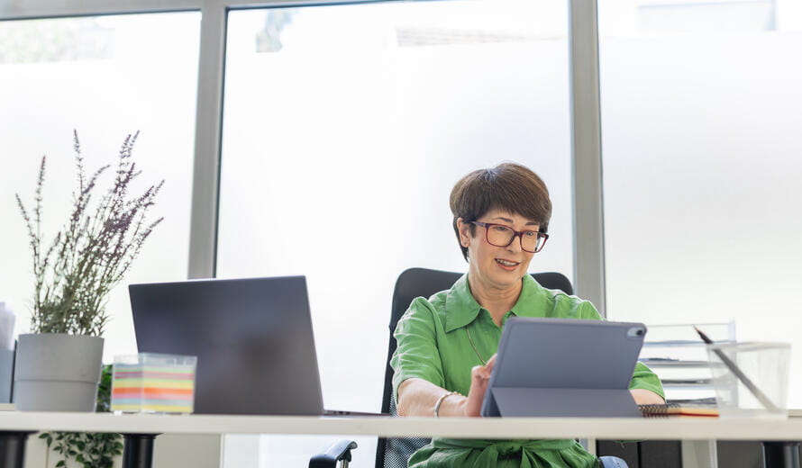 A middle aged woman working on digital tablet.