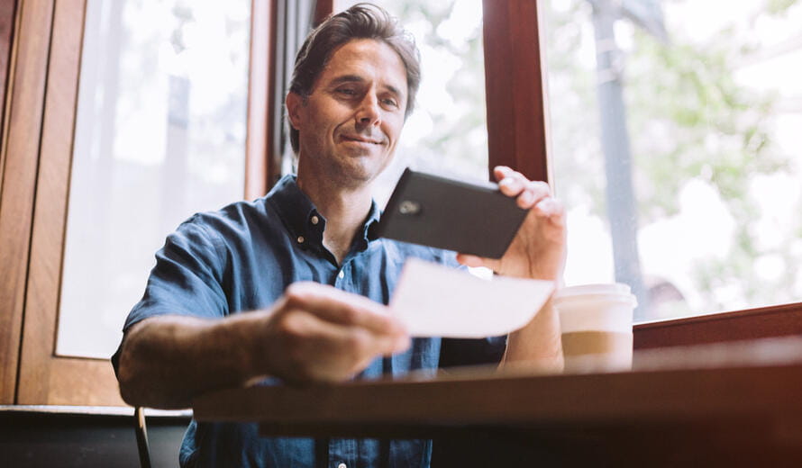 A mature smiling man in his mid 40's takes a picture.