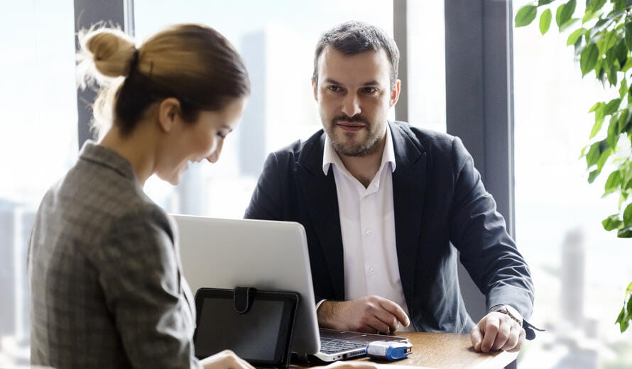 Young businesswoman and businessman signing contract in office