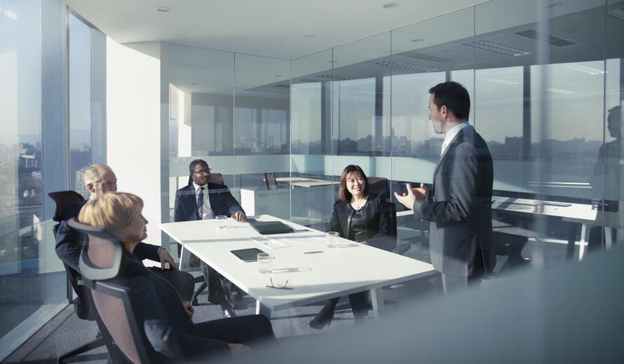 Adult businessman leader boss CEO executive with group of business people team sitting together in conference meeting room