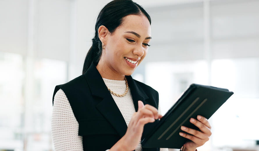 Woman reviewing business reports on a digital tablet in a modern office