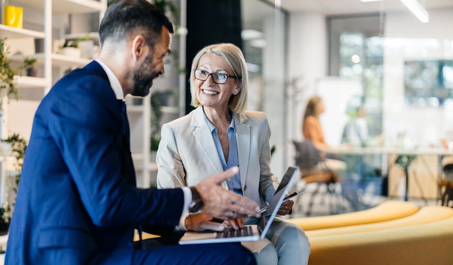 Experienced senior manager discussing work with a male coworker