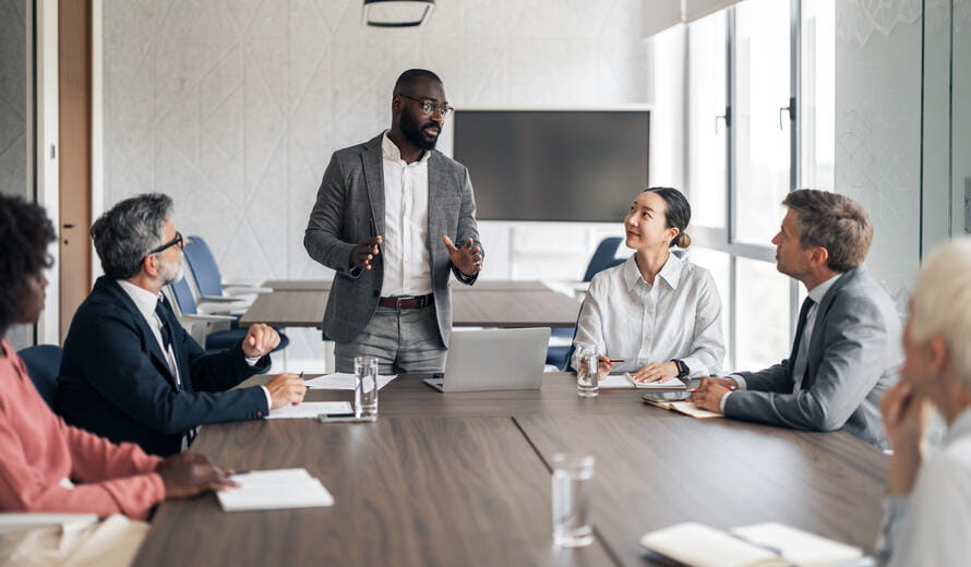  businessman presenting strategy to a diverse team in a modern boardroom