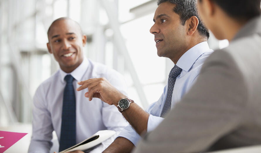 An image showing a few businessmen engaged in a discussion.