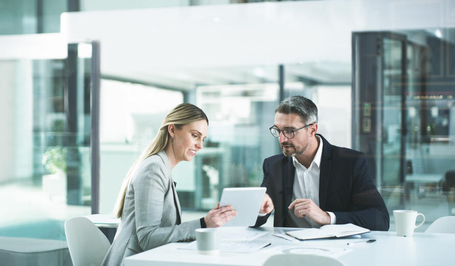 Shot of two businesspeople working together on a digital tablet in an office