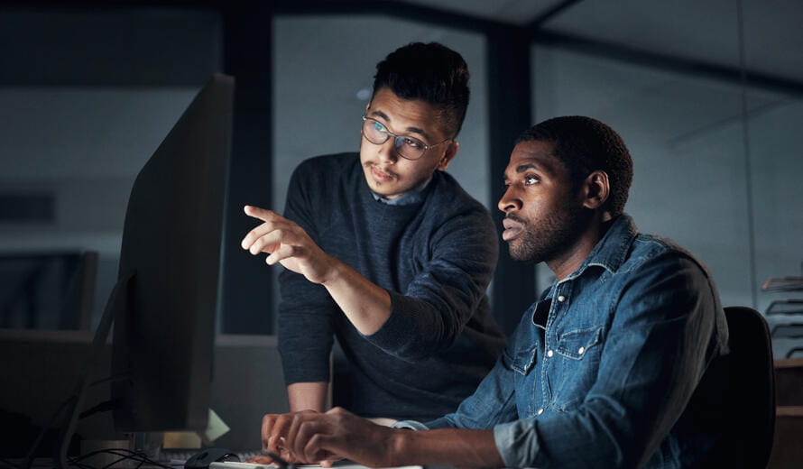 two men looking at a computer