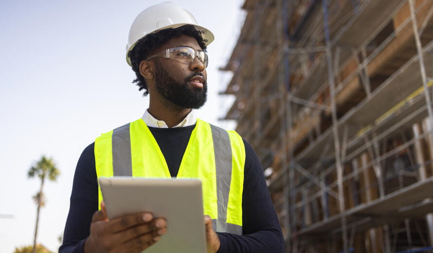 A young black man is a project manager at a residential construction site.