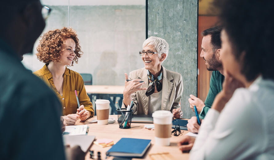 Mixed group of business people sitting around a table and talking