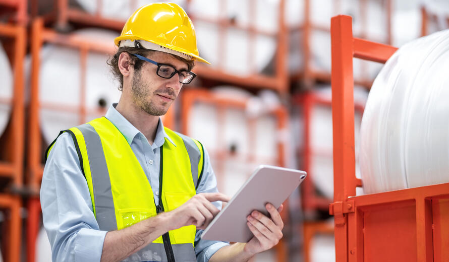 Male Manufacturers Engineer working at warehouse or storehouse of plastic bag manufacturers.Worker check product before shipping and transport to customer, Storage for plastic bag at factory.