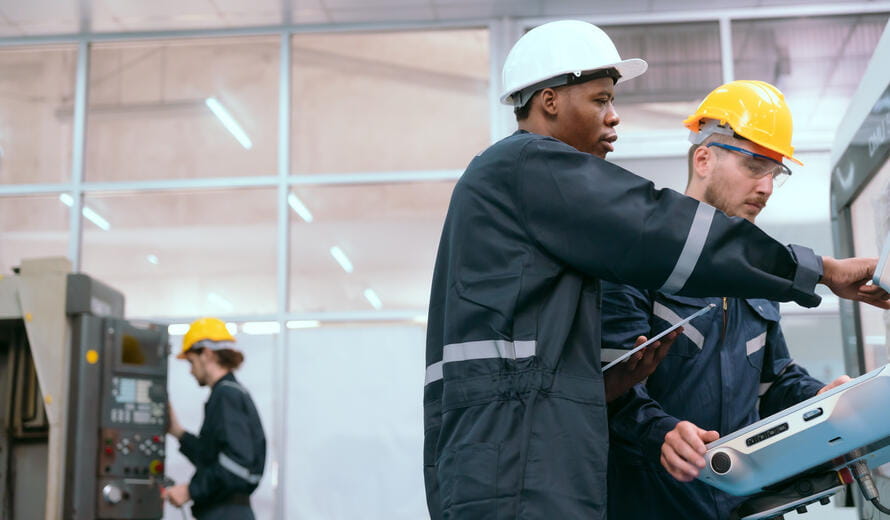 A team of maintenance engineers discussing and inspecting robotic arm machines in the lab. factory machinery