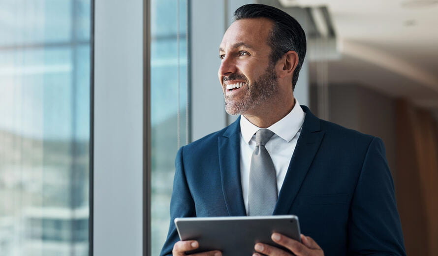 man smiling with a tablet