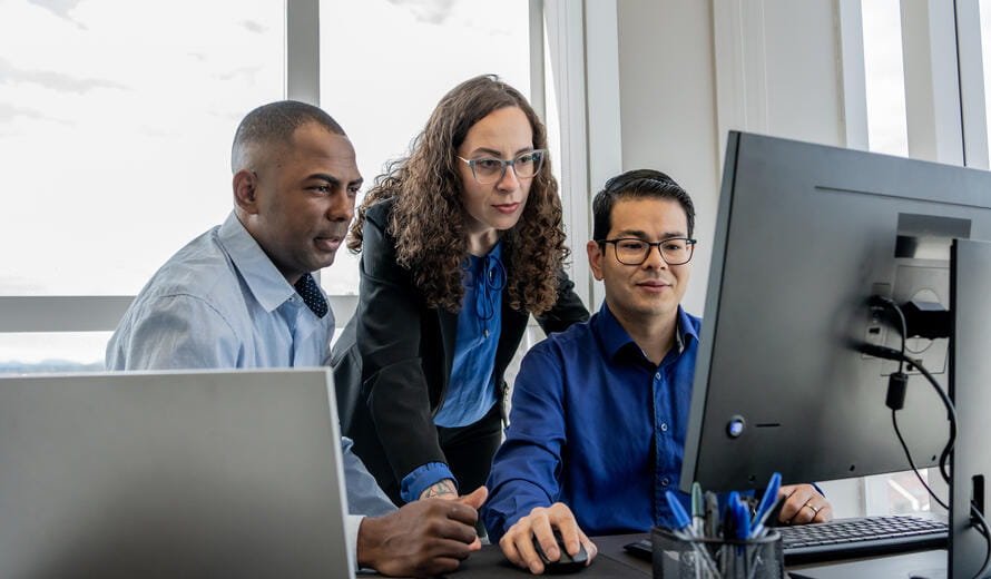 Cybersecurity team discussing in front of a monitor screen