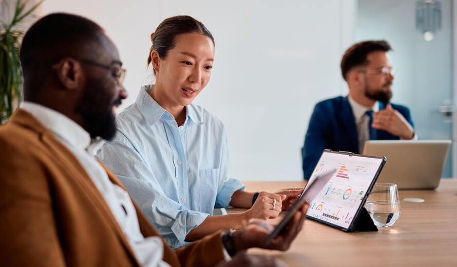 a group of people sitting at a table looking at a laptop