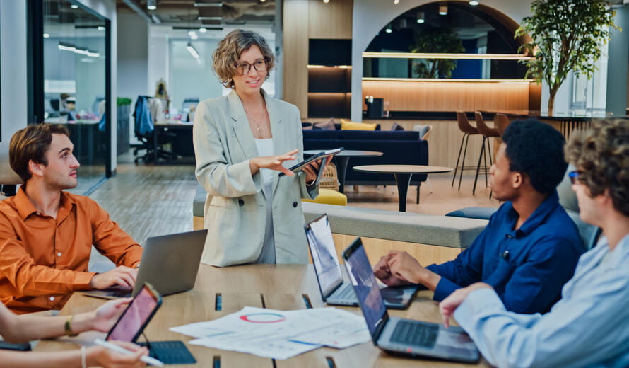 Diverse business team presents company data and performance charts meeting discussing strategy planning investment marketing strategies in office. Sustainable business and finance concept.
