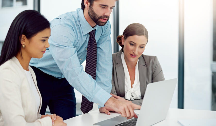 a group of people looking at a laptop