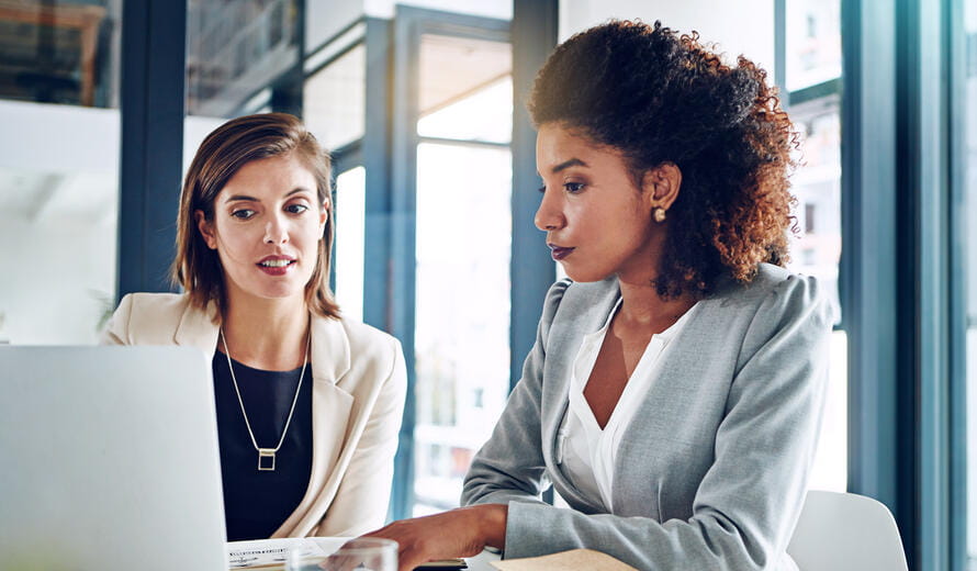 two women looking at a laptop