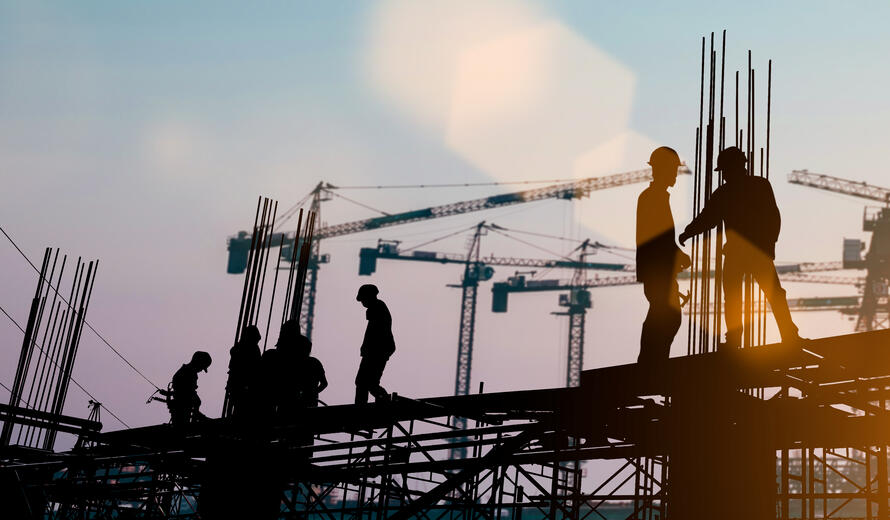 Silhouette of engineer and construction team working at site over blurred background sunset
