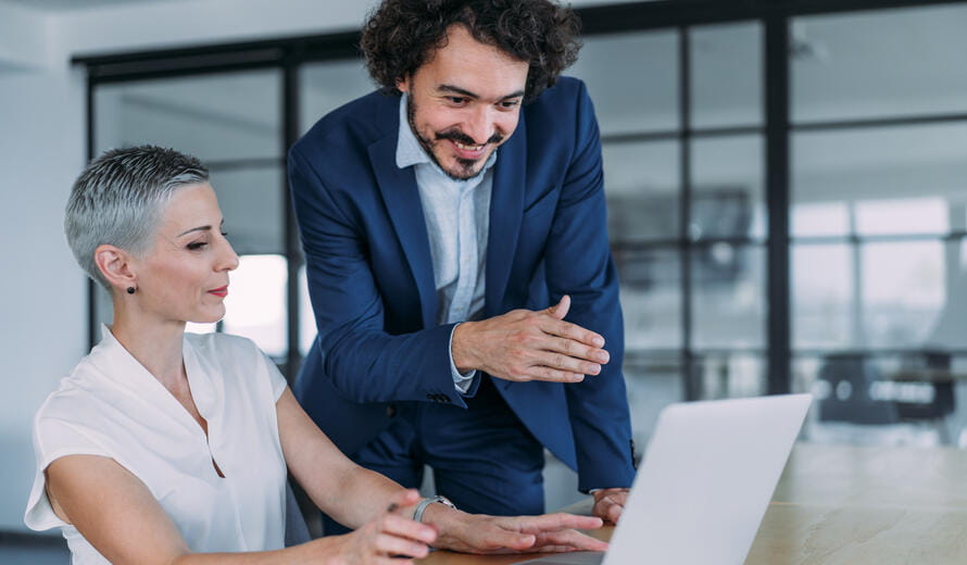 man and woman looking at a laptop