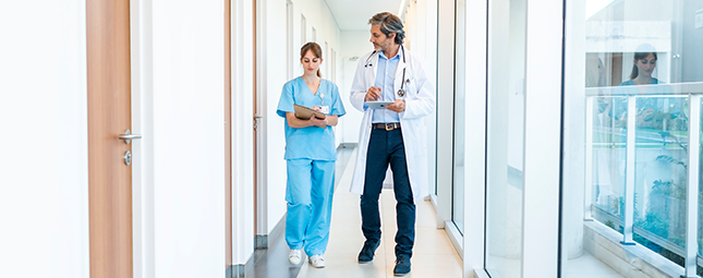 two healthcare workers walking through a hallway