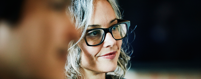 close up of a gray haired woman in glasses