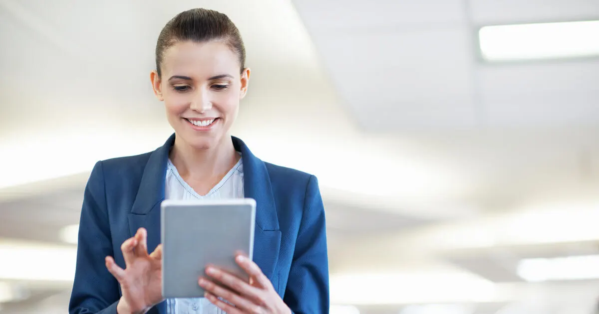 Shot of a young office worker standing in an office using a digital tablet